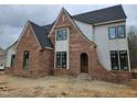 Brick and siding construction features black window frames and arched doorway at 109 Evander Way, Pittsboro, NC 27312