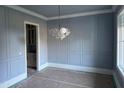 Dining Room featuring wainscoting and a modern chandelier at 129 Windel Dr, Raleigh, NC 27609