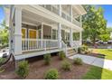 Charming two-story condo with double porches, white railings, and landscaped front yard, creating a welcoming facade at 1300 Broad St # A, Durham, NC 27705