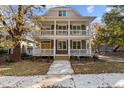 Charming two-story home with a double front porch, white railings, and a walkway at 1300 Broad St # A, Durham, NC 27705