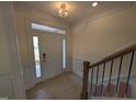 Bright entryway featuring hardwood floors, elegant trim, and a beautiful staircase at 19 Grassland Dr, Garner, NC 27529
