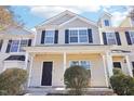 Two-story townhome, beige and gray siding, covered porch at 207 Hampshire Downs Dr, Morrisville, NC 27560