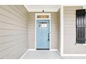 Close-up of a bright blue front door with glass panel and stylish black hardware and matching shutter at 213 Quarter Gate Trace, Chapel Hill, NC 27516