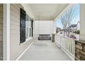 Inviting front porch with a relaxing swing, stone columns, and views of the neighborhood at 213 Quarter Gate Trace, Chapel Hill, NC 27516