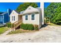 Tan house with red door, wooden steps, deck, and driveway at 2313 Havering Pl, Raleigh, NC 27604