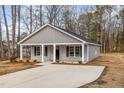 Newly built home with gray siding, a covered porch and a concrete driveway at 307 E Pope Ave, Kenly, NC 27542
