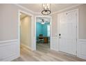 Bright entryway with wood-look floors, leading to an office with a teal wall at 312 Trinity Creek Dr, Holly Springs, NC 27540