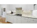 Modern kitchen features granite countertops and sleek, white cabinets at 3701 Baron Cooper Pass # 205, Raleigh, NC 27612