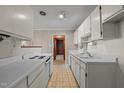 Galley kitchen with white cabinets and appliances at 507 Stokes Rd, Graham, NC 27253