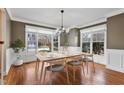 Charming dining room featuring hardwood floors, wainscoting, neutral paint, and a view of the front yard at 7416 Capulin Crest Dr, Apex, NC 27539