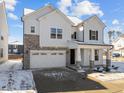 Two-story house with white siding, stone accents, and a two-car garage in winter setting at 800 Summit Crest Ct, Apex, NC 27523