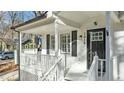 Close-up of front porch, with white railing and lattice, black door, and black shuttered windows at 1014 Holden Rd, Youngsville, NC 27596