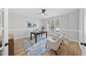 Bright home office with hardwood floors, natural light, a ceiling fan, and ample space for productivity at 109 Aspenridge Dr, Holly Springs, NC 27540