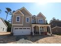 Charming two-story home featuring a welcoming front porch, attached garage, and neutral toned siding at 1105 Opal Ln # 70, Durham, NC 27705