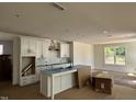 Bright, white kitchen featuring a kitchen island, modern finishes, and stainless-steel appliances at 1105 Opal Ln # 70, Durham, NC 27705