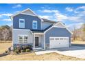 Two-story house with blue siding, stone accents, and a two-car garage at 148 Aylebury Rdg, Zebulon, NC 27597