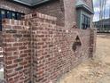 Detail shot of a red brick exterior wall with diamond cutout and window to the home at 274 Westhampton Dr, Pittsboro, NC 27312