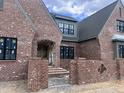 Close up of brick home's arched front entrance and brick retaining wall at 274 Westhampton Dr, Pittsboro, NC 27312