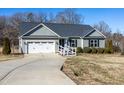 Gray siding house with a white garage door and landscaping at 3038 Bramblegate Dr, Mebane, NC 27302