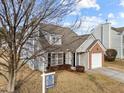 House exterior with gray siding, brick accents, and a two-car garage at 3838 Potecasi Dr, Raleigh, NC 27610