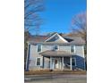 Front exterior of a gray, two-story house with a metal roof and a small front porch at 411 E Green St, Franklinton, NC 27525