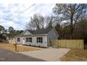Cozy home featuring new vinyl siding, a small yard, and a newly-poured concrete driveway at 420 E Cedar Ave, Wake Forest, NC 27587
