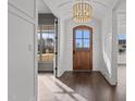 Inviting foyer with a wooden front door, chandelier, and dark hardwood floors at 4912 Hidden Pasture Way, Zebulon, NC 27597