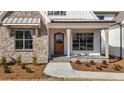 Charming front entrance featuring a wooden door and stone accents at 4912 Hidden Pasture Way, Zebulon, NC 27597