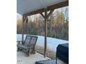 Covered patio with wooden bench, grill, and wooded views at 538 Lionheart Ln, Sanford, NC 27330