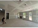 Open-concept living area with fireplace rough-in, large windows, and staircase; currently under construction at 1109 Opal Ln # 71, Durham, NC 27705