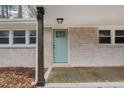 Charming exterior features a quaint covered entryway with stylish blue front door and brick facade at 1302 Buffaloe Rd, Garner, NC 27529