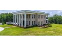 Elegant two-story home with prominent columns, beautiful landscaping, and a well-maintained lawn at 14425 Nc-96 N Hwy, Zebulon, NC 27597