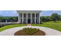 Elegant home featuring prominent columns, manicured landscaping, and a circular driveway at 14425 Nc-96 N Hwy, Zebulon, NC 27597