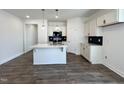 Modern kitchen featuring a center island, white cabinets, stainless steel appliances and dark backsplash at 150 W Saltgrass Ln, Smithfield, NC 27577