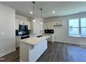 Bright kitchen with a large island, modern pendant lighting, sleek appliances, and dark backsplash at 150 W Saltgrass Ln, Smithfield, NC 27577
