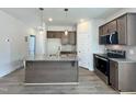 Modern kitchen featuring stainless steel appliances, a gray island, and stylish pendant lighting at 160 W Saltgrass Ln, Smithfield, NC 27577