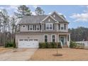 Two-story house with gray siding, white garage door, and teal front door at 296 Wilson Farm Ln, Clayton, NC 27527