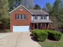Charming two-story home with a brick facade, attached garage, and a well-manicured front yard at 6645 Austin Creek Dr, Wake Forest, NC 27587