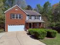 Charming two-story home with a brick facade, attached garage, and a well-manicured front yard at 6645 Austin Creek Dr, Wake Forest, NC 27587