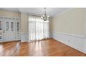 Dining room with hardwood flooring, chair railing, and a door to the outside at 701 Occoneechee Dr, Fuquay Varina, NC 27526