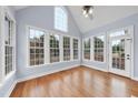 Sun room filled with natural light from large windows, vaulted ceiling, and hardwood floors at 701 Occoneechee Dr, Fuquay Varina, NC 27526