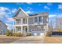 Two-story house with gray siding, a two-car garage, and a landscaped front yard at 7949 Parker Mill Trl, Fuquay Varina, NC 27526