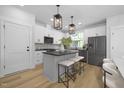 Modern kitchen with island, white cabinets, and stainless steel appliances at 917 Myers Point Dr # 21, Morrisville, NC 27560