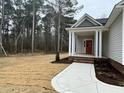 Red front door, brick steps, and covered porch with columns at 100 Preacher Ln, Angier, NC 27501