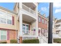 Townhome's front porch with balcony, steps, and landscaping at 10510 Sablewood Dr # 110, Raleigh, NC 27617