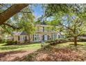 Beautiful two-story home with a spacious front yard and mature trees providing shade at 110 E Orange St, Hillsborough, NC 27278