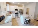 Modern kitchen with white cabinets, granite countertops, and stainless steel appliances at 1404 Hollyview Ave, Durham, NC 27703