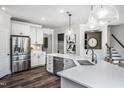 Spacious kitchen with a large island, stainless steel appliances, white cabinets, and wood-look floors at 15 Rosedale Way, Pittsboro, NC 27312