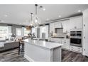 Open-concept kitchen with white cabinets, quartz countertops, stainless steel appliances, and pendant lighting at 15 Rosedale Way, Pittsboro, NC 27312