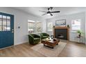 Inviting living room with a fireplace, modern ceiling fan, and views of the landscaped outdoors at 1606 James St, Durham, NC 27707